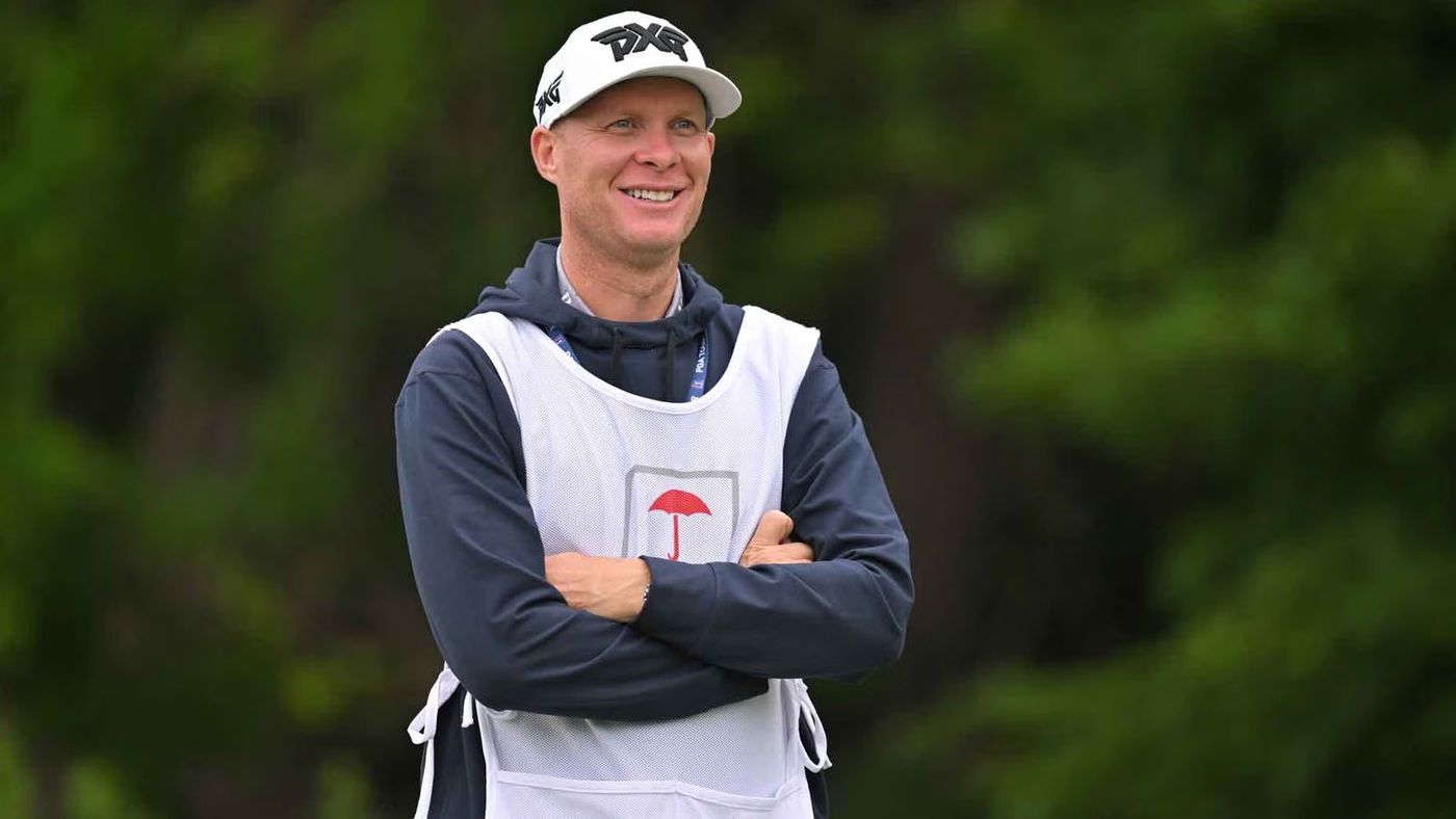 Geno Bonnalie, PGA Tour caddie, on the course in a caddie bib.